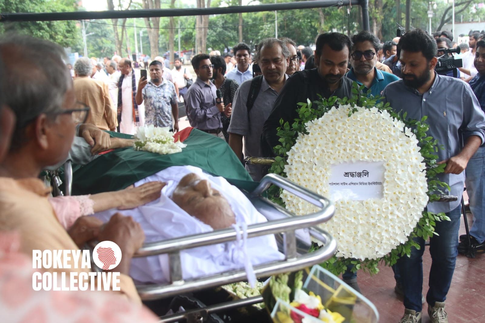 বরেণ্য চিত্রশিল্পী ও সাংস্কৃতিক ব্যক্তিত্ব মুস্তাফা মনোয়ারের প্রতি শেষ শ্রদ্ধা জানাতে মঙ্গলবার কেন্দ্রীয় শহীদ মিনারে শ্রদ্ধা নিবেদন করেন বিভিন্ন শ্রেণি-পেশার মানুষ। এ সময় রাষ্ট্রের পক্ষ থেকে তাঁকে গার্ড অব অনার প্রদান করা হয়।  পরে বিভিন্ন সামাজিক, সাংস্কৃতিক ও পেশাজীবী সংগঠনের পাশাপাশি স্বজন, সহকর্মী ও শুভানুধ্যায়ীরা ফুল দিয়ে তাঁর প্রতি শেষ শ্রদ্ধা জানান। দেশের শিল্প ও সংস্কৃতিতে তাঁর অবদানের কথা স্মরণ করেন উপস্থিতরা। ছবি: তাহিয়াত নাজিফা নুর/ রোকেয়া কালেকটিভ।
