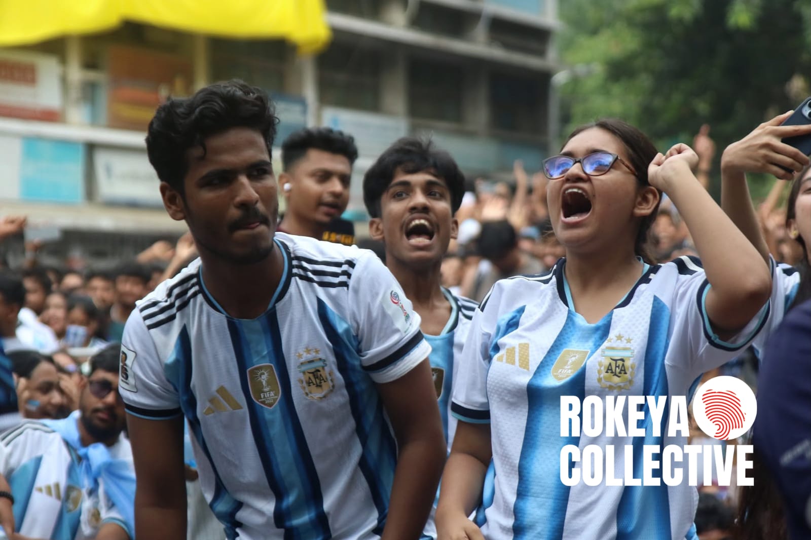 ঢাকা বিশ্ববিদ্যালয়ের শহীদুল্লাহ্ হলের মাঠে খেলা দেখতে যাওয়া এক নারীকে বের করে দেওয়ার প্রতিবাদে একই মাঠে ও টিএসসিতে একসঙ্গে আর্জেন্টিনা-জর্ডান ম্যাচ উপভোগ করেছেন বিশ্ববিদ্যালয়ের নারী শিক্ষার্থীরা। ম্যাচ শেষে তারা ক্যাম্পাসে নারীর নিরাপত্তা, মর্যাদা এবং বৈষম্যহীন অবাধ চলাচলের অধিকার নিশ্চিতের দাবিতে প্রক্টর কার্যালয়ে স্মারকলিপি দেন।  ছবি: তাহিয়াত নাজিফা নুর/রোকেয়া কালেকটিভ। ২৮ জুন ২০২৬।
